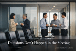 decision making in China illustrated by an empty conference room while executives talk and align in the hallway